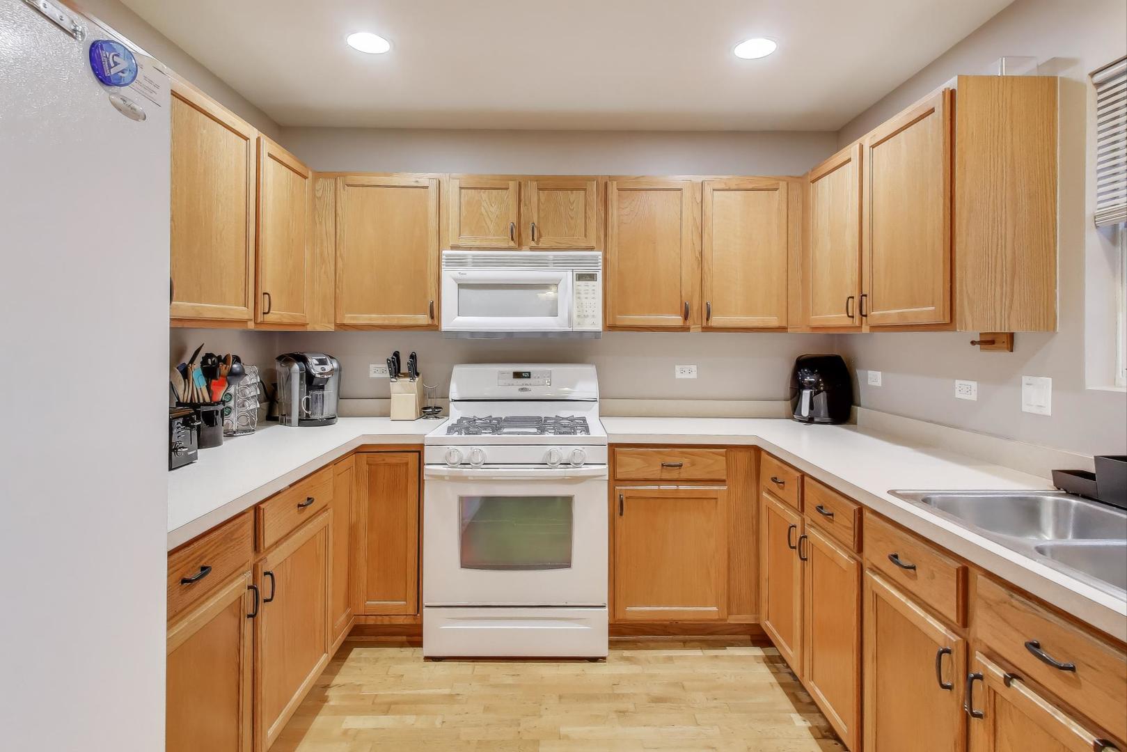 104 Waterbury Circle Oswego, IL 60543 - Photo 10 of 23 a kitchen with stainless steel appliances granite countertop a stove a sink and white cabinets