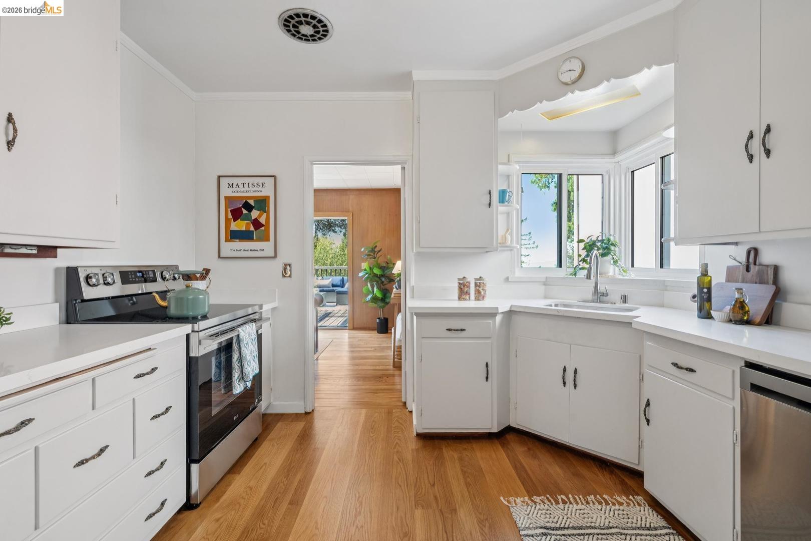 155 Avenida Drive Berkeley, CA 94708 - Photo 25 of 86 Kitchen featuring white cabinetry, light-toned countertops, wood-finish flooring, and a stainless steel oven