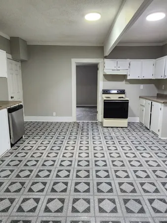 a kitchen with granite countertop a stove a sink and a microwave
