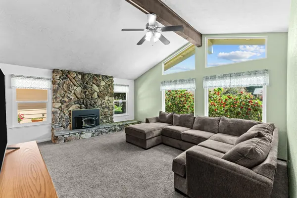 a living room with furniture a large window and a fireplace
