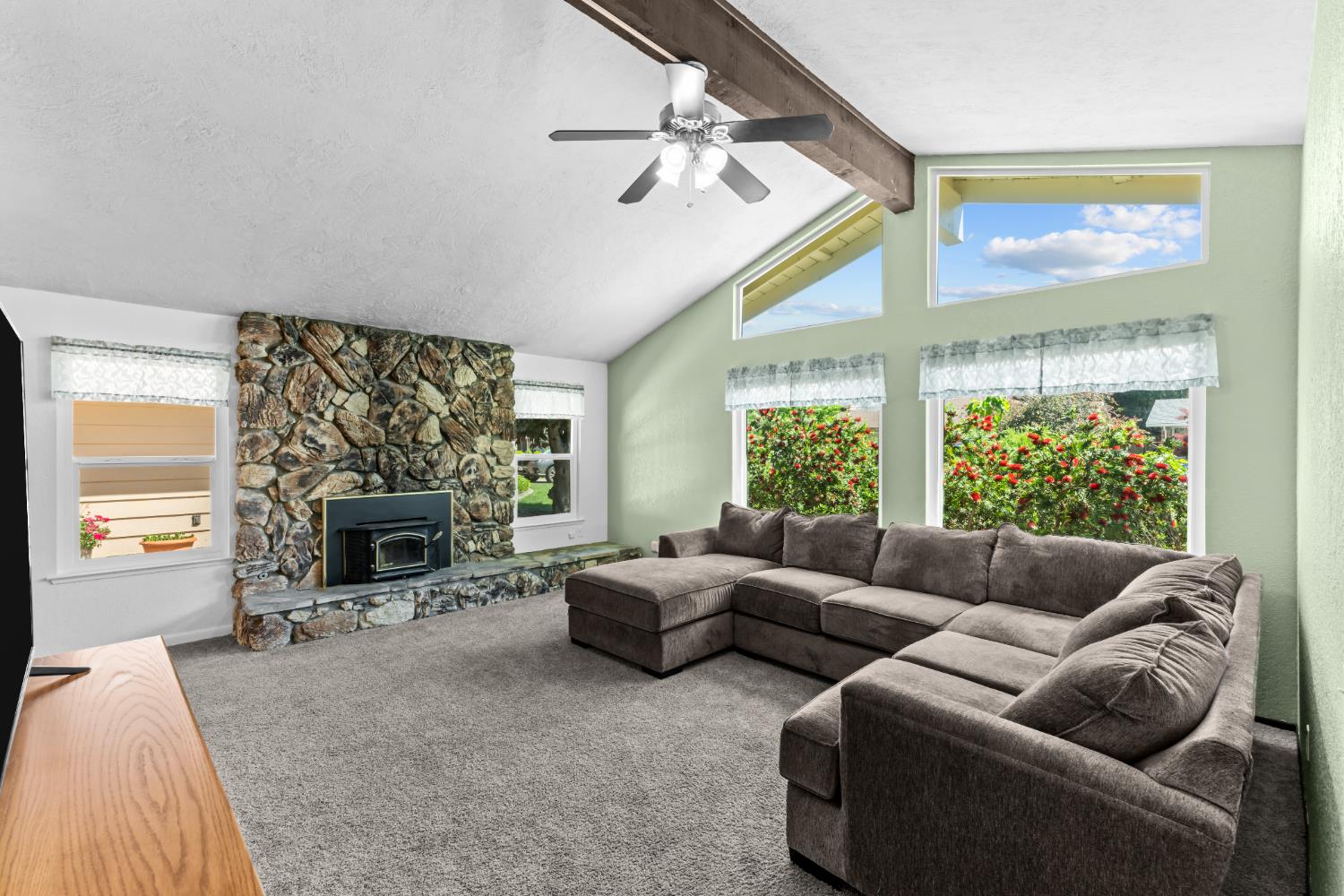 a living room with furniture a large window and a fireplace
