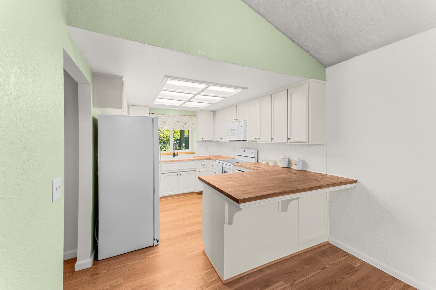 3395 Meadow Way Rocklin, CA 95677 - Photo 6 of 35 a kitchen with a stove a refrigerator and wooden floor
