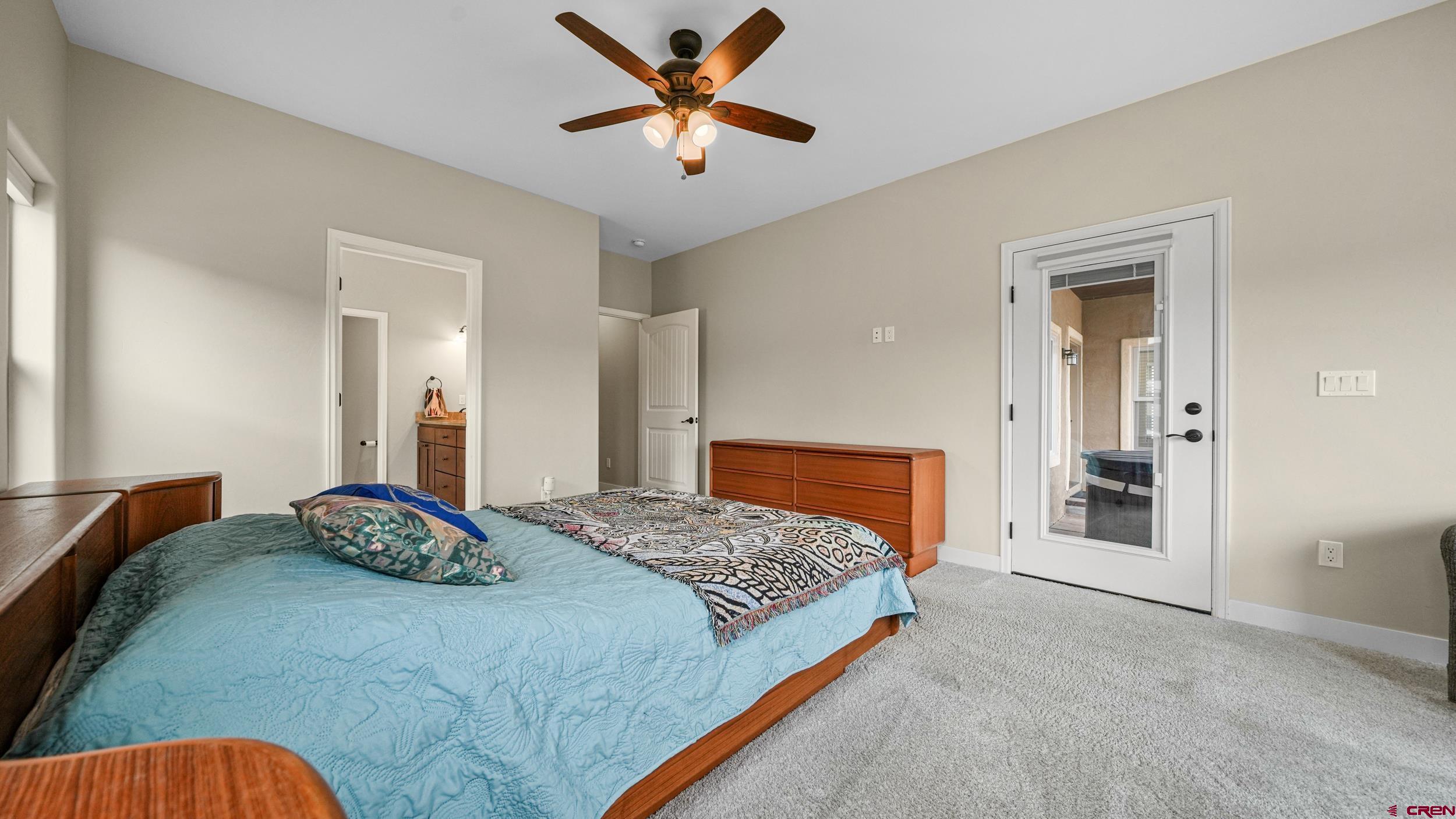 2042 Constitution Loop Montrose, CO 81401 - Photo 15 of 42 a bedroom with a bed and a chandelier