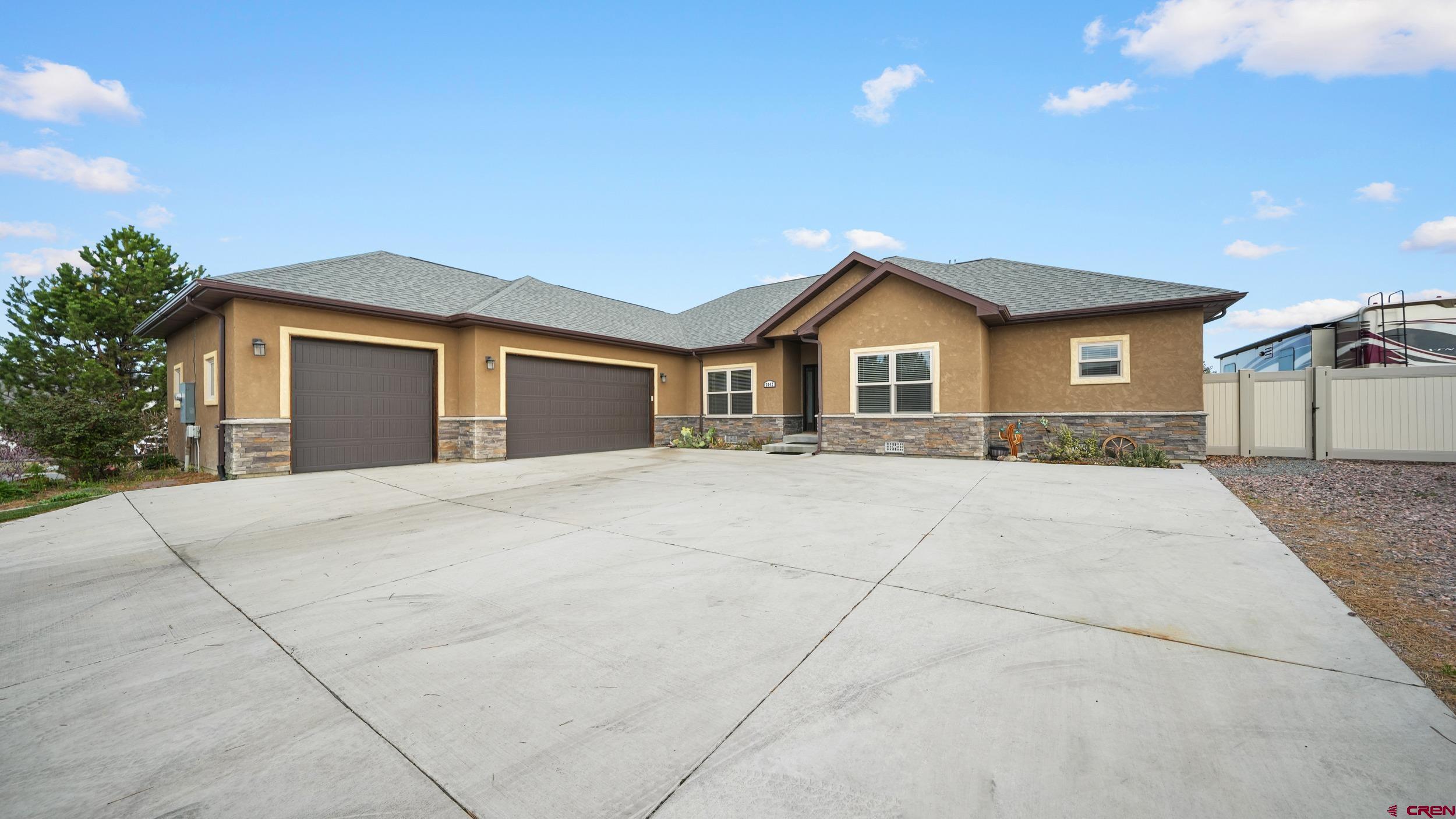 2042 Constitution Loop Montrose, CO 81401 - Photo 2 of 42 a front view of a house with a yard and garage