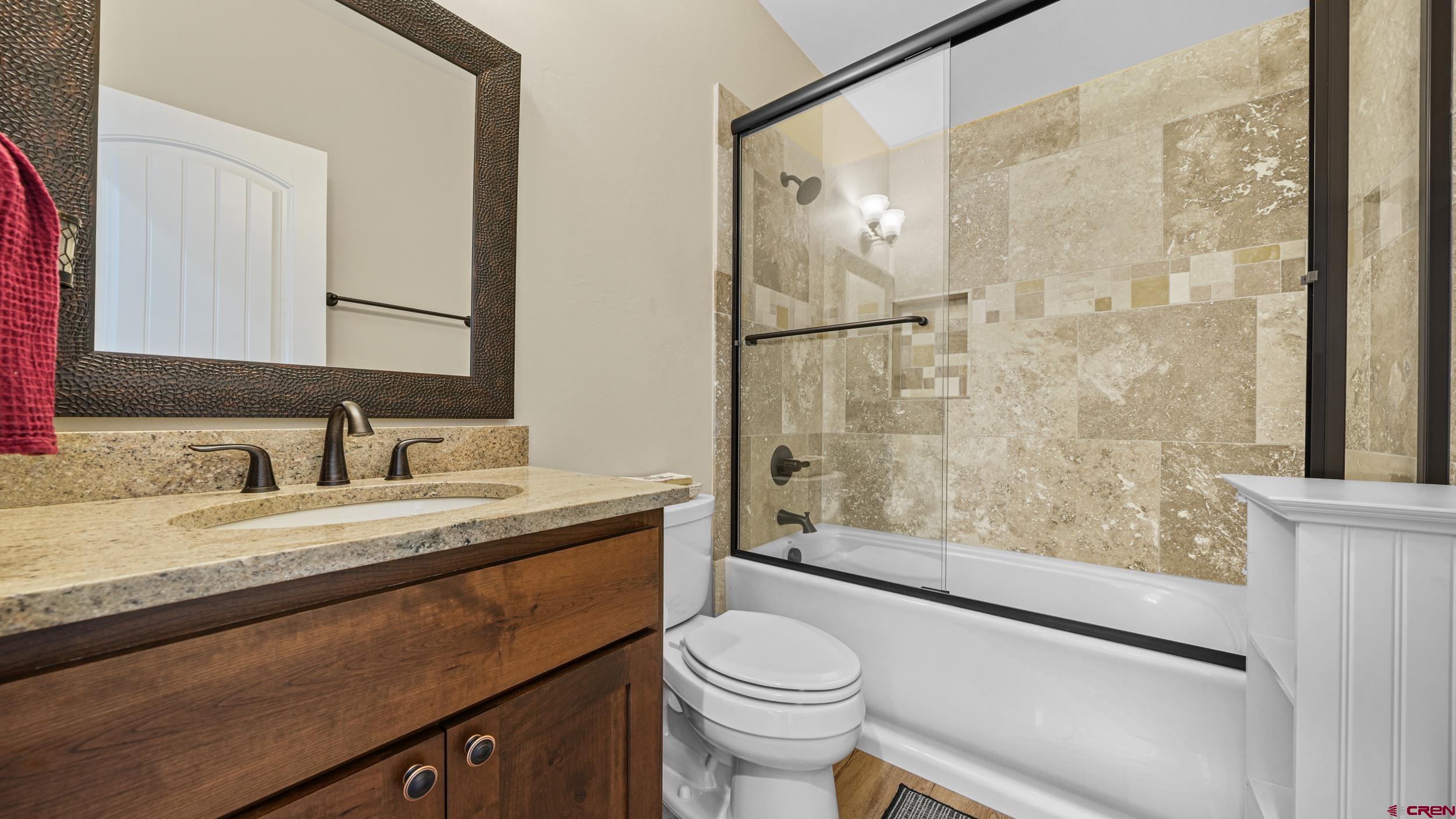 2042 Constitution Loop Montrose, CO 81401 - Photo 26 of 42 a bathroom with a granite countertop sink mirror vanity and toilet