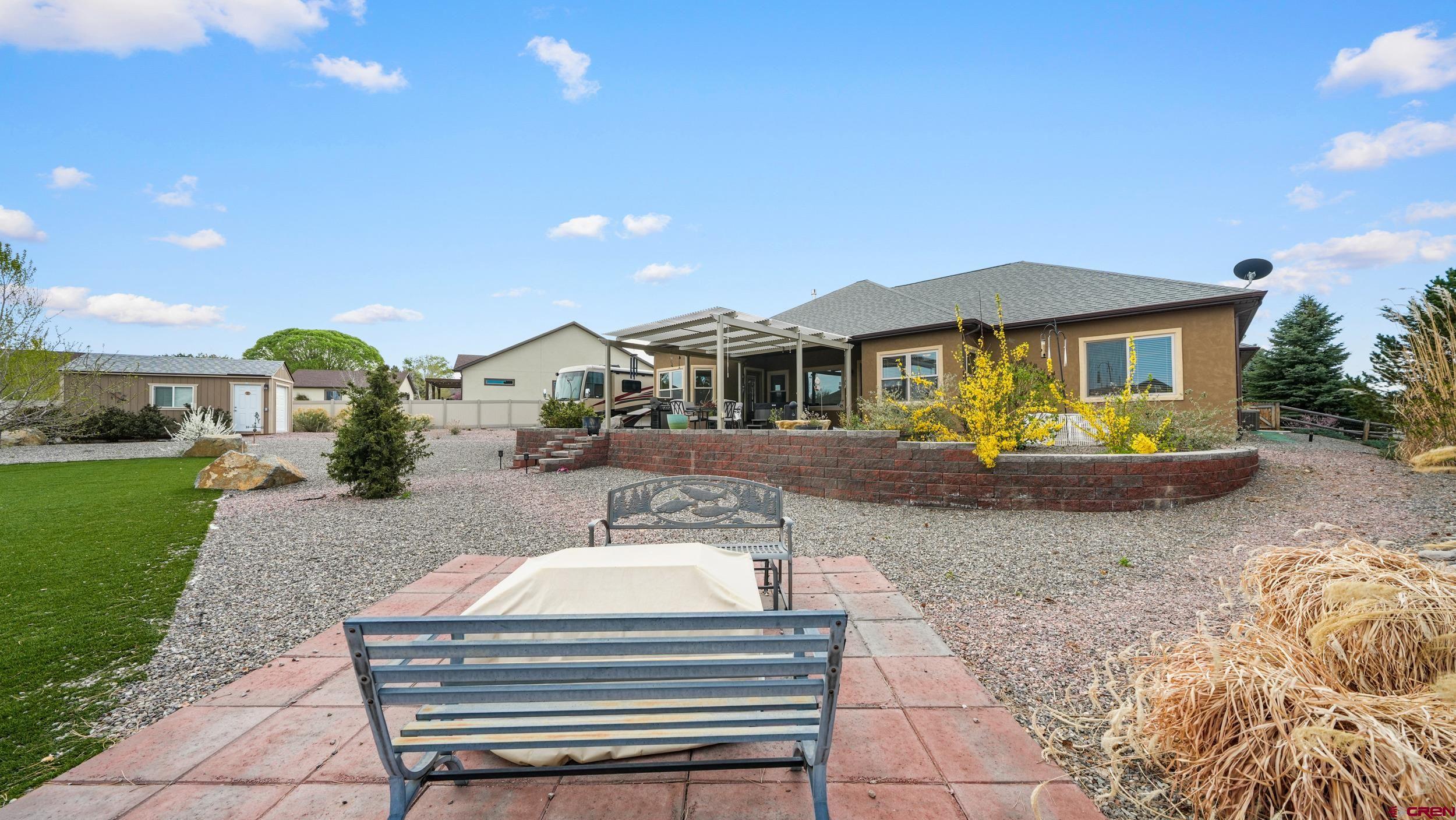 2042 Constitution Loop Montrose, CO 81401 - Photo 27 of 42 a front view of a house with a yard and potted plants