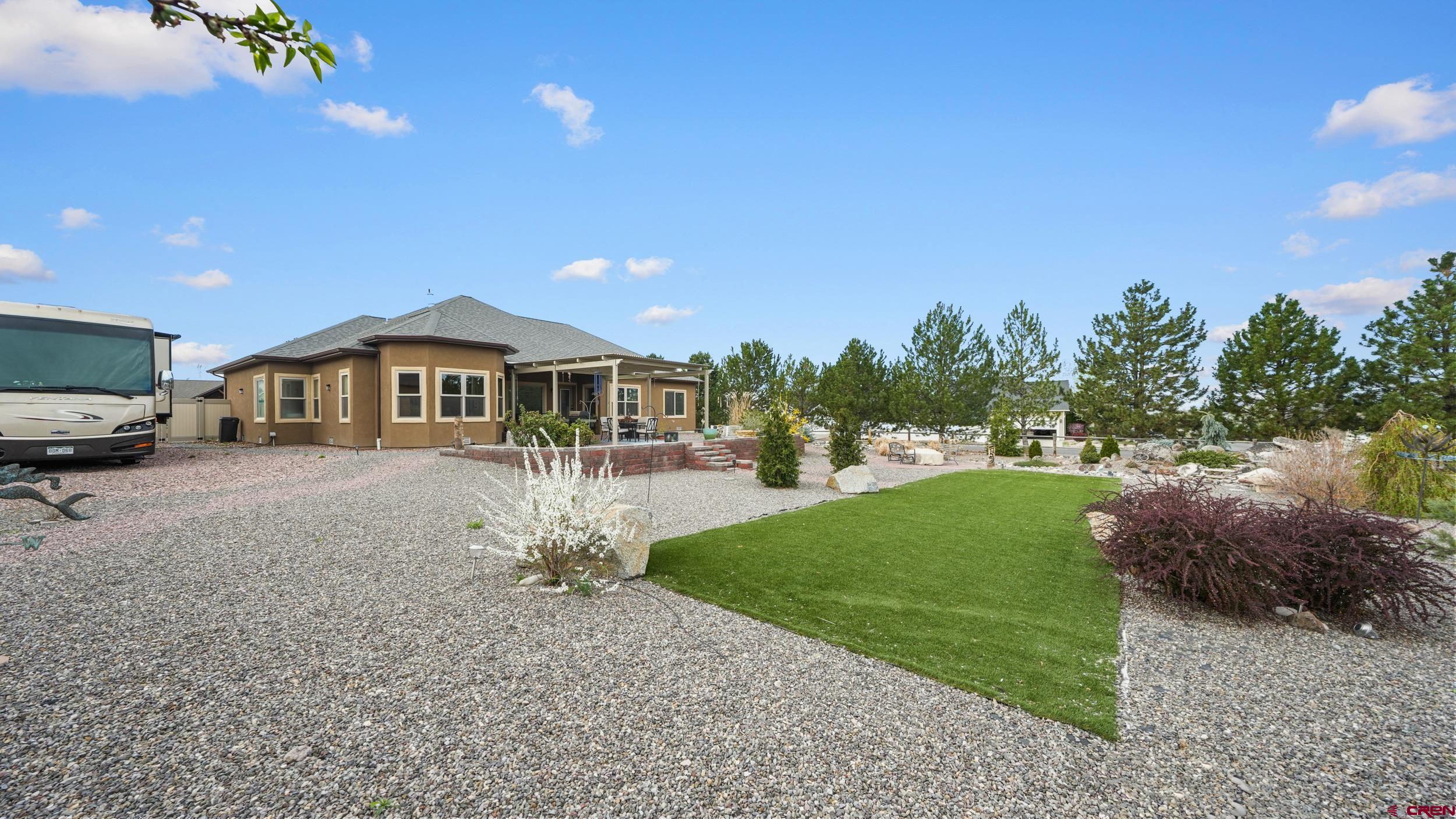 2042 Constitution Loop Montrose, CO 81401 - Photo 29 of 42 a front view of a house with a yard and trees