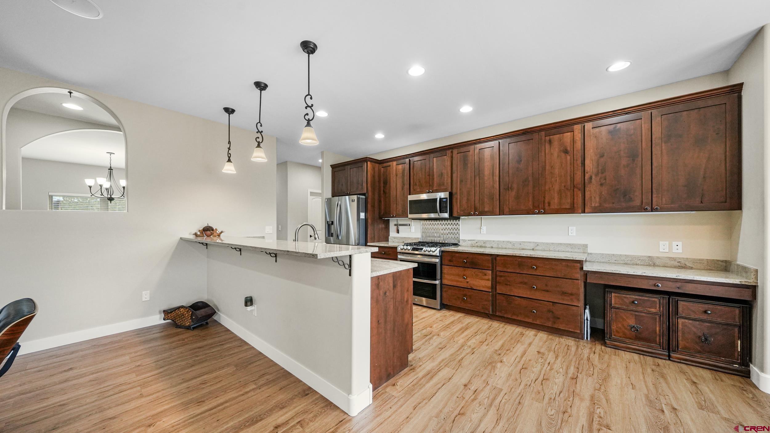 2042 Constitution Loop Montrose, CO 81401 - Photo 8 of 42 a kitchen with wooden floors and wooden cabinets
