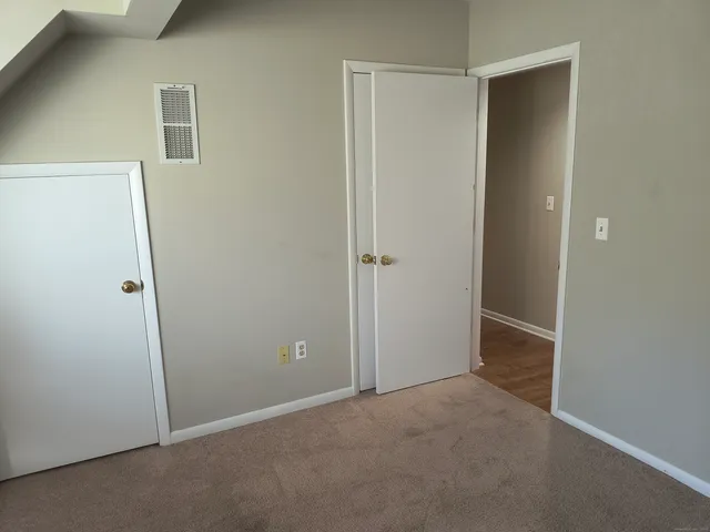 an empty room that has a glass door and closet