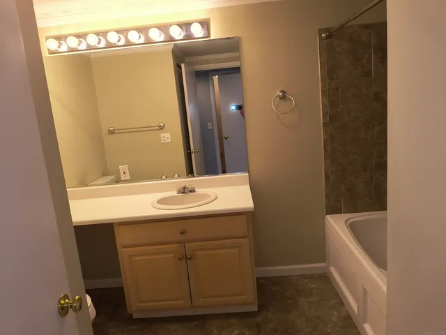 a bathroom with a sink and mirror with toilet