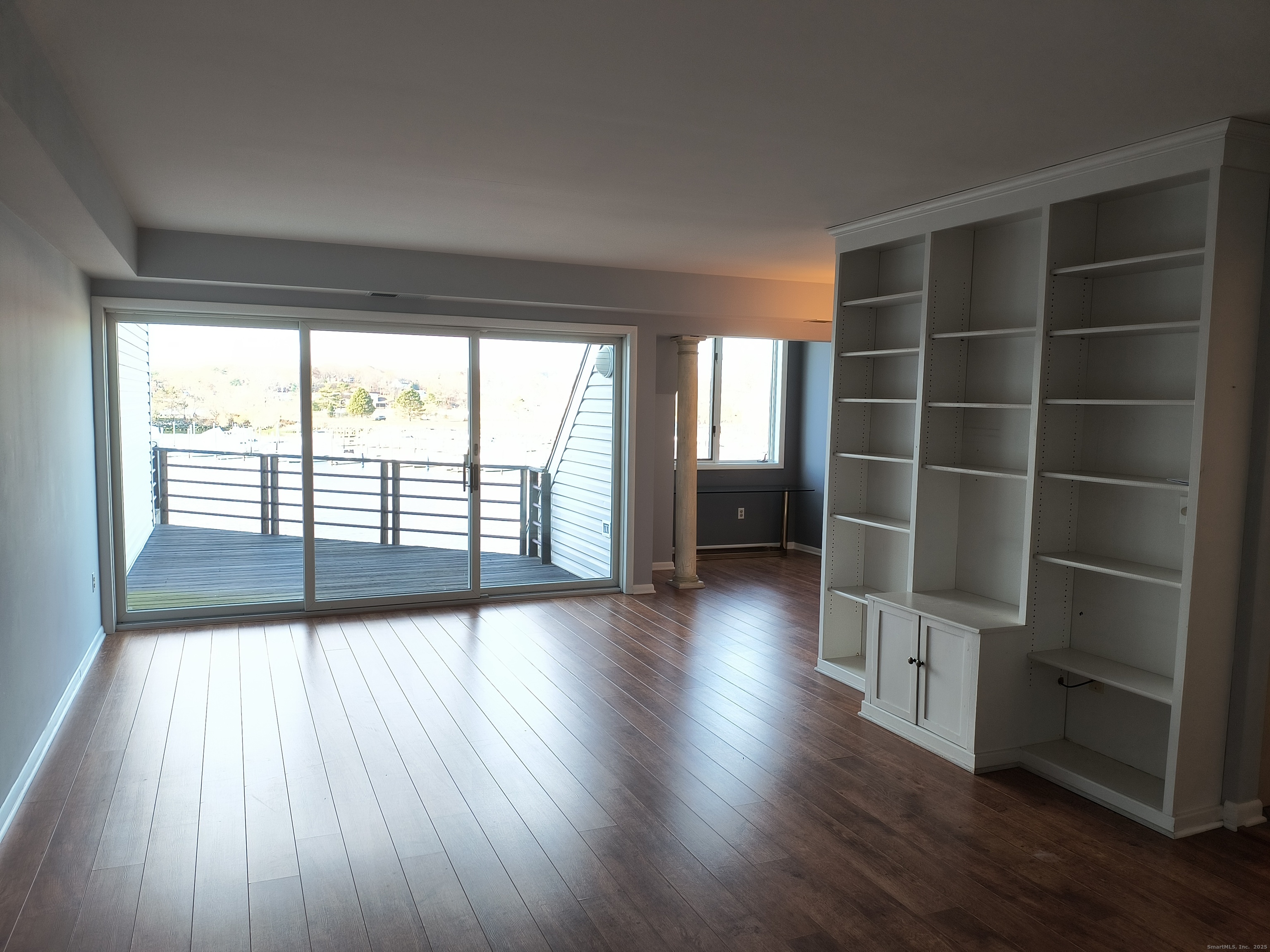 532 Popes Island Road, Unit 532 Milford, CT 06461 - Photo 5 of 23 a view of an empty room with a window and wooden floor