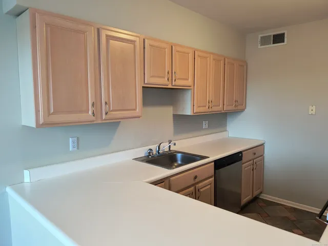 a kitchen with stainless steel appliances granite countertop a sink and a white cabinets