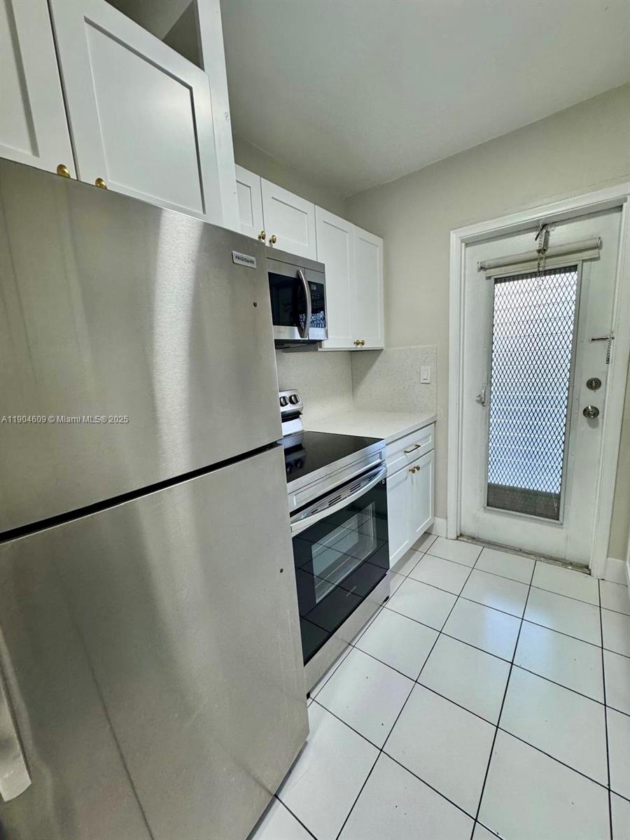 a kitchen with stainless steel appliances a refrigerator sink and microwave