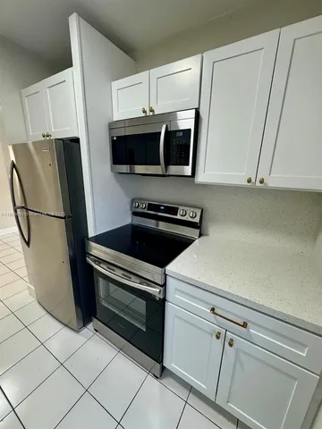 a kitchen with stainless steel appliances a refrigerator a stove a microwave and cabinets