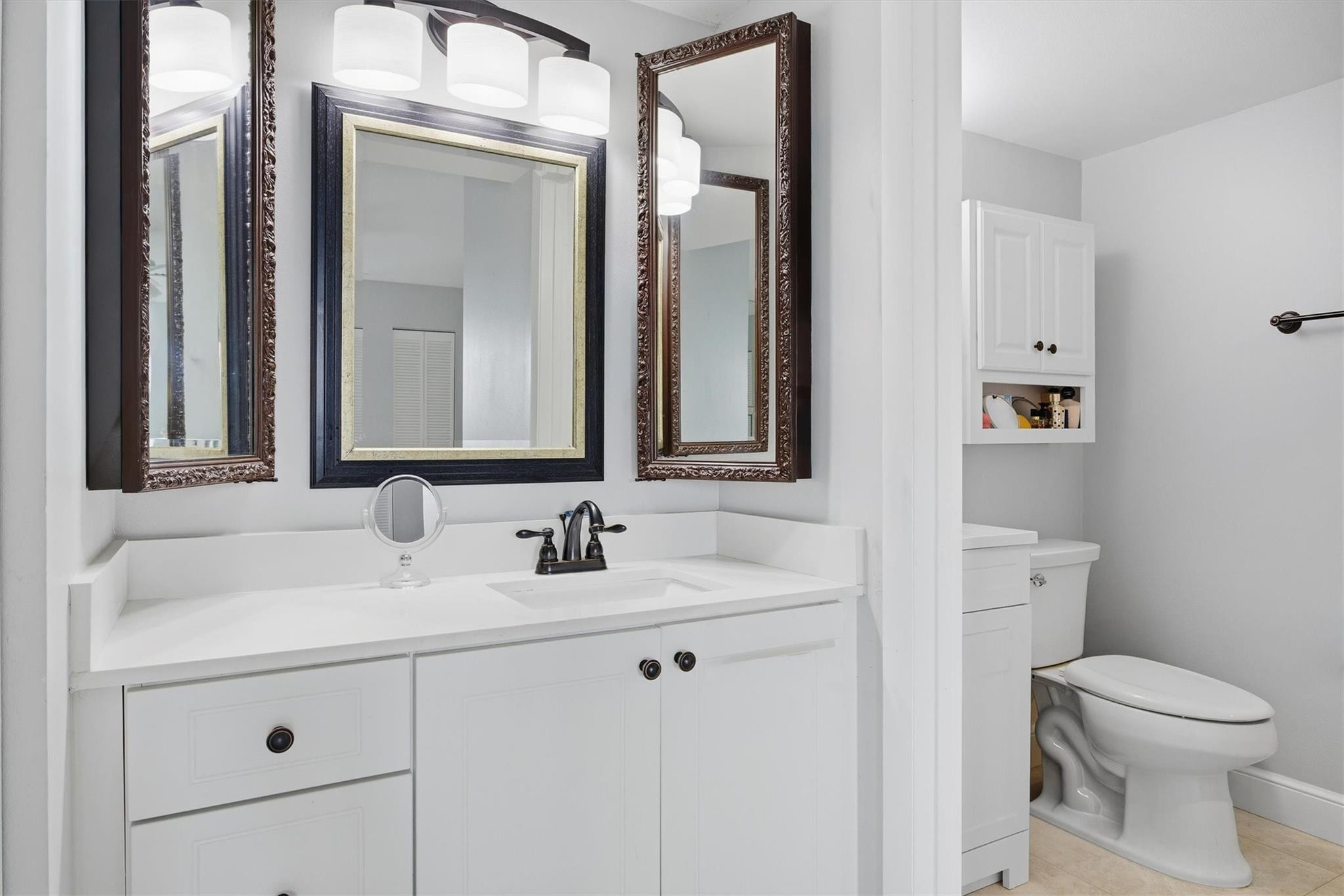3910 Inverrary Boulevard, Unit 708B Lauderhill, FL 33319 - Photo 22 of 58 a bathroom with a toilet sink and mirror