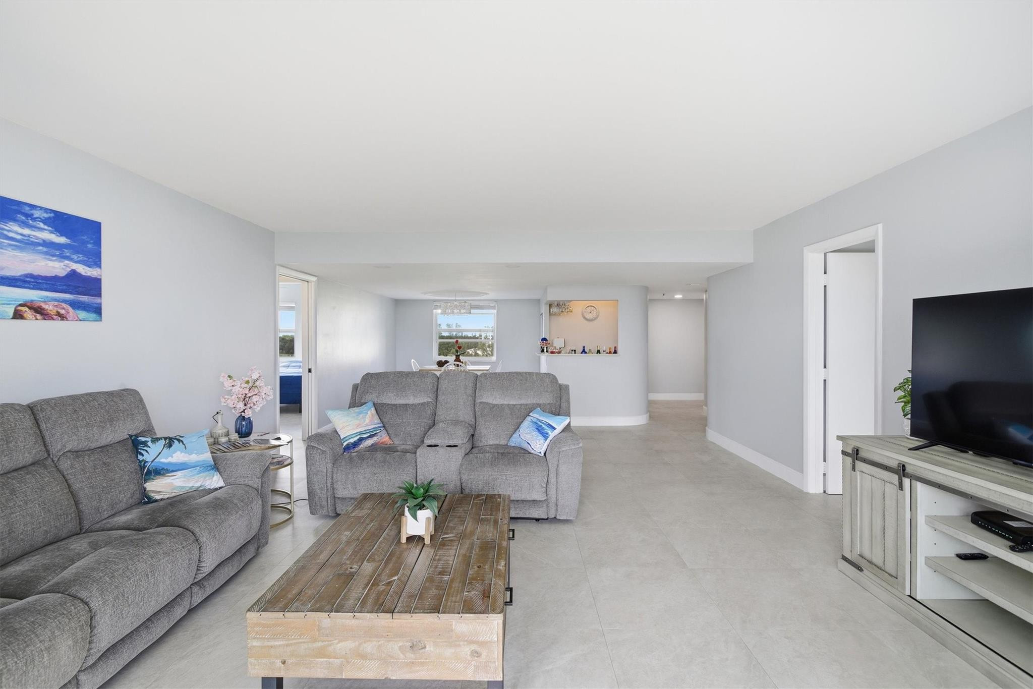 3910 Inverrary Boulevard, Unit 708B Lauderhill, FL 33319 - Photo 9 of 58 a living room with furniture and a flat screen tv