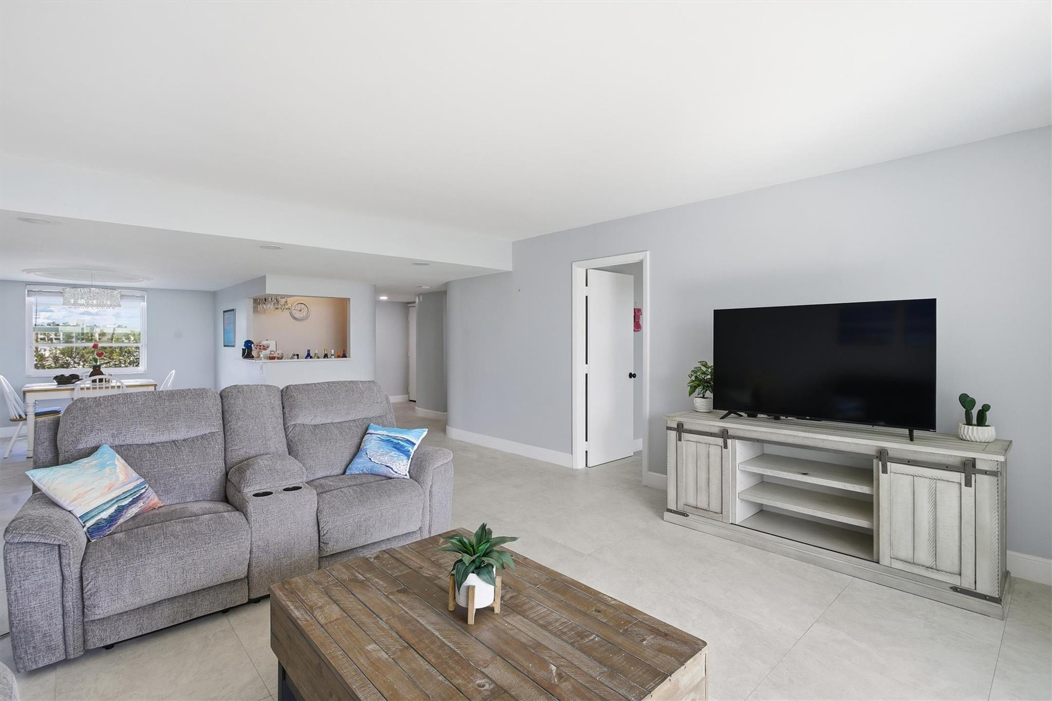 3910 Inverrary Boulevard, Unit 708B Lauderhill, FL 33319 - Photo 10 of 58 a living room with furniture and a flat screen tv