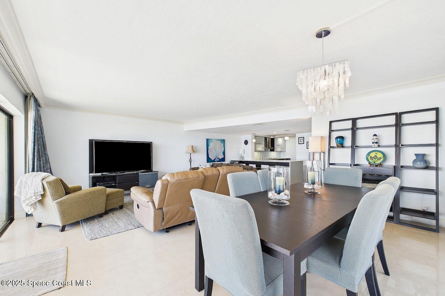 55 North 4th Street, Unit 401 Cocoa Beach, FL 32931 - Photo 11 of 34 a living room with furniture kitchen view and a flat screen tv