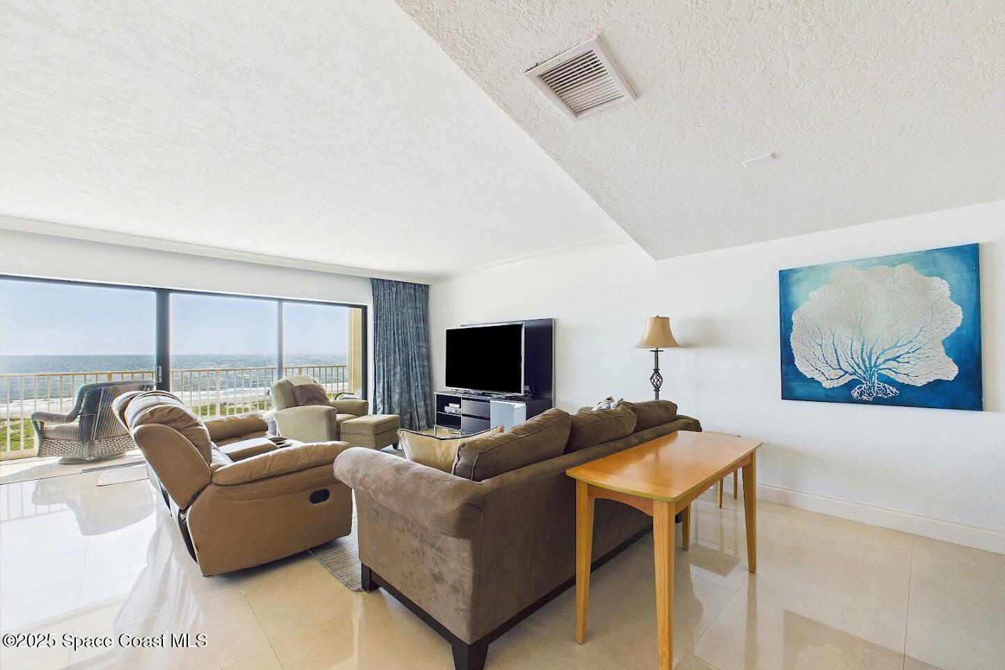 55 North 4th Street, Unit 401 Cocoa Beach, FL 32931 - Photo 12 of 34 a living room with furniture and a flat screen tv