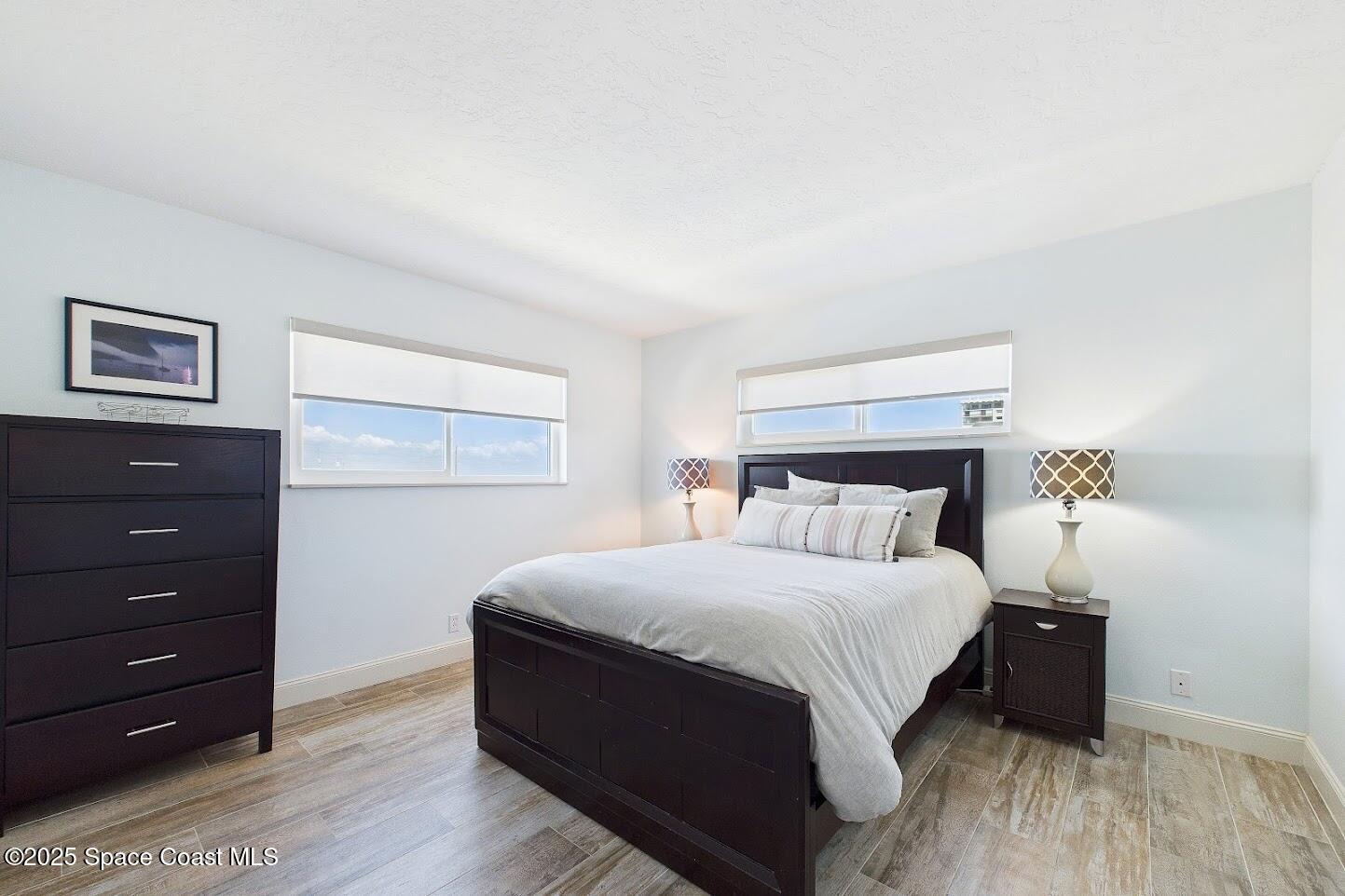 55 North 4th Street, Unit 401 Cocoa Beach, FL 32931 - Photo 26 of 34 a bedroom with a bed and a night stand