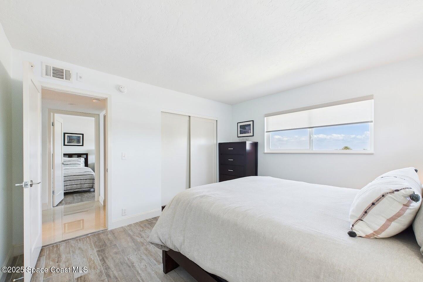 55 North 4th Street, Unit 401 Cocoa Beach, FL 32931 - Photo 27 of 34 a bedroom with a bed and a view of bathroom