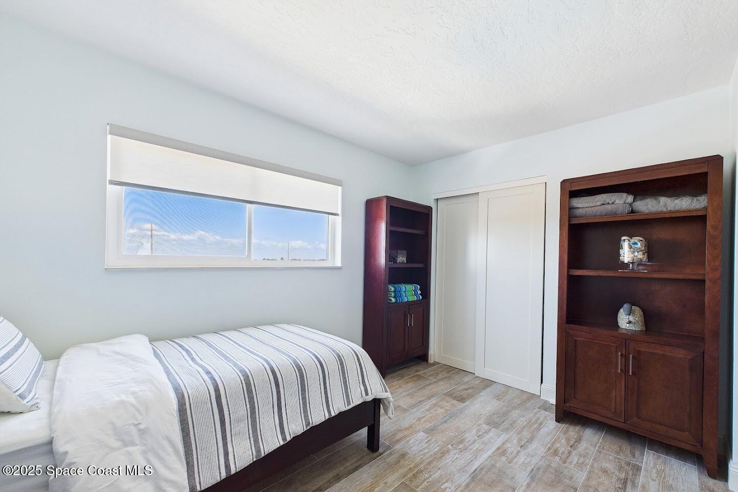 55 North 4th Street, Unit 401 Cocoa Beach, FL 32931 - Photo 30 of 34 a bedroom with a bed and a closet