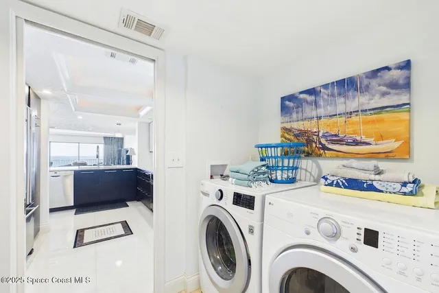 a view of washer and dryer with kitchen in the background