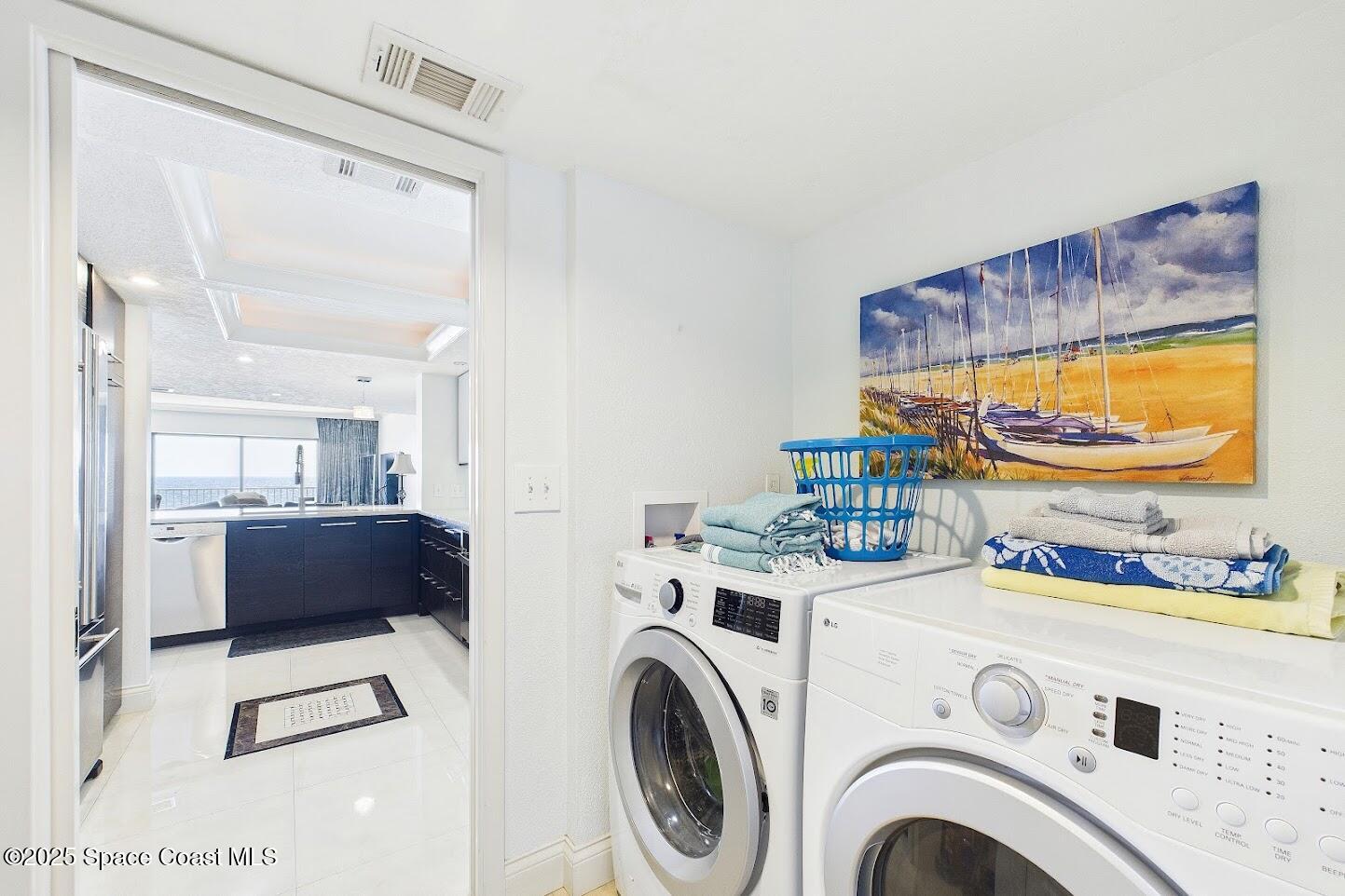 55 North 4th Street, Unit 401 Cocoa Beach, FL 32931 - Photo 31 of 34 a view of washer and dryer with kitchen in the background