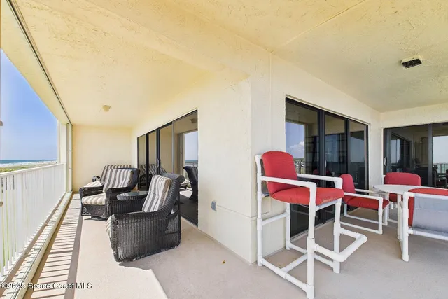 a living room with furniture a window and red carpet