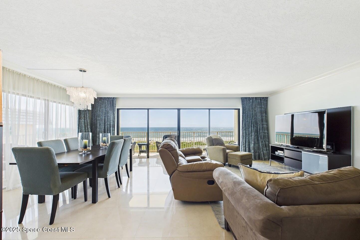 55 North 4th Street, Unit 401 Cocoa Beach, FL 32931 - Photo 9 of 34 a living room with furniture and a flat screen tv