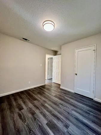 a view of an empty room with wooden floor