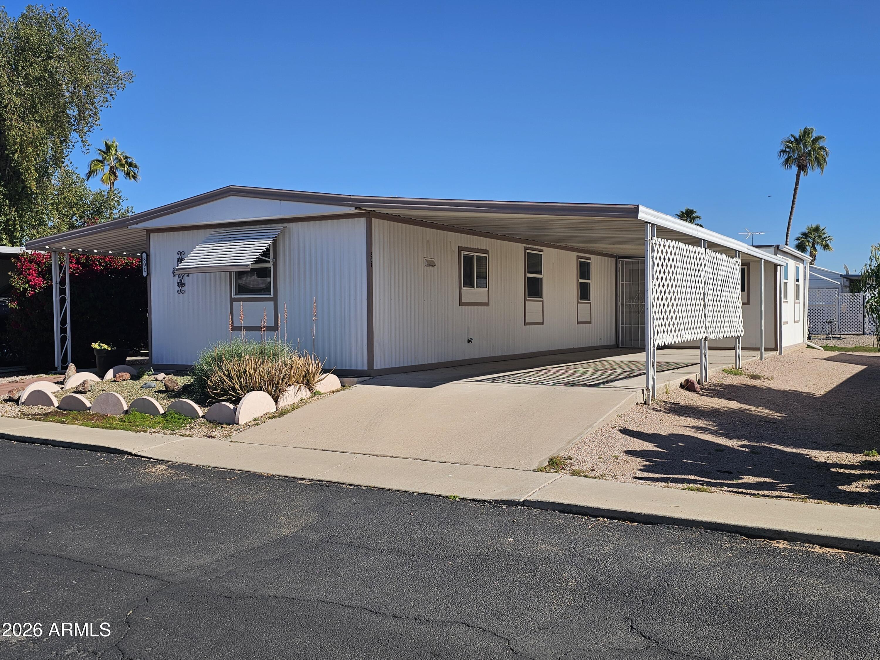 3405 South Tomahawk Road, Unit 301 Apache Junction, AZ 85119 - Photo 2 of 10 a front view of a house with a yard