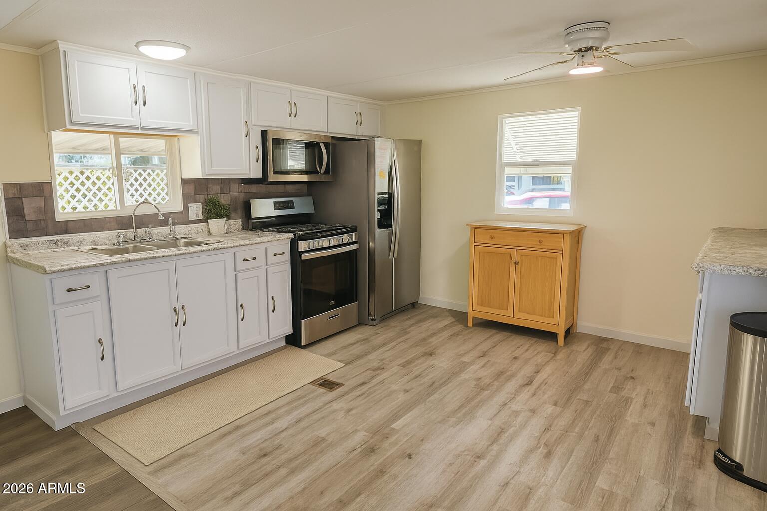 3405 South Tomahawk Road, Unit 301 Apache Junction, AZ 85119 - Photo 3 of 10 a kitchen with granite countertop a stove a sink and a refrigerator