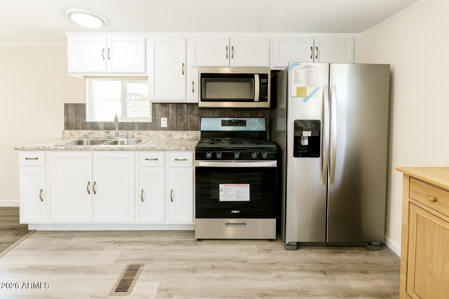 3405 South Tomahawk Road, Unit 301 Apache Junction, AZ 85119 - Photo 5 of 10 a kitchen with stainless steel appliances a stove a refrigerator and a sink