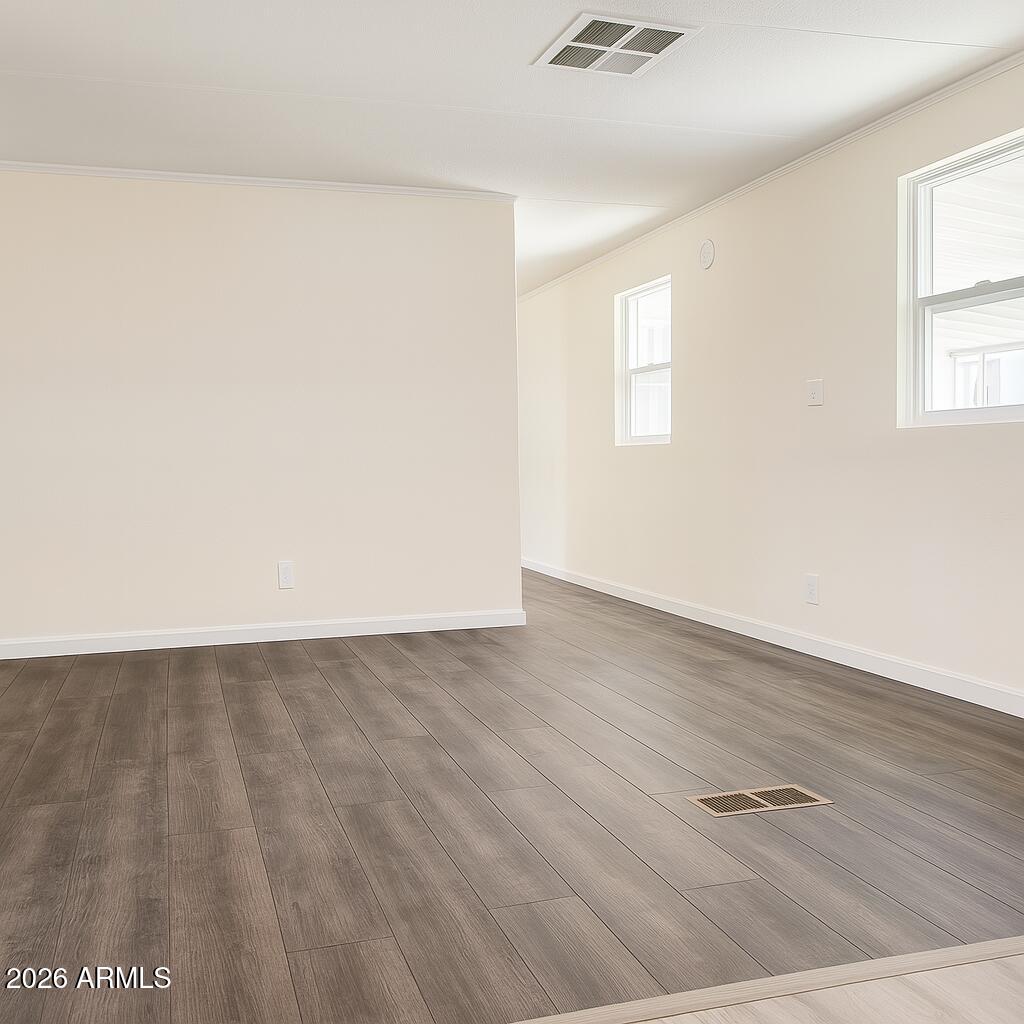 3405 South Tomahawk Road, Unit 301 Apache Junction, AZ 85119 - Photo 9 of 10 an empty room with wooden floor and windows