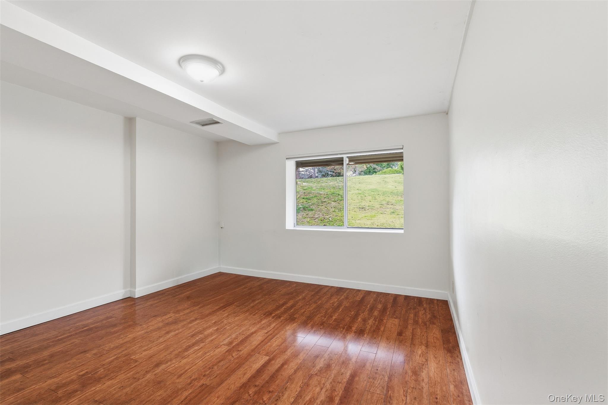17 Knoll View Ossining, NY 10562 - Photo 27 of 34 an empty room with wooden floor and windows
