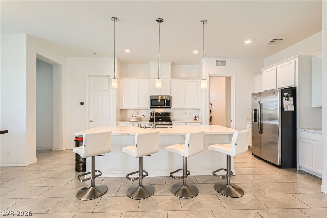 498 Pebble Run Avenue Henderson, NV 89011 - Photo 8 of 47 This contemporary kitchen features an inviting island with pendant lighting, perfect for casual dining and entertaining.