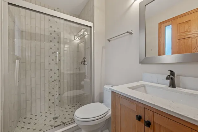 a bathroom with a sink a toilet and shower
