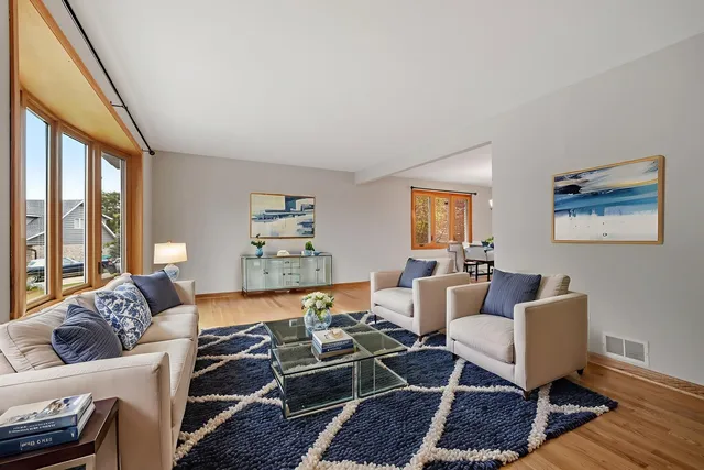 a living room with furniture a rug and a large window