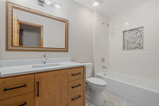 a bathroom with a toilet a sink and mirror