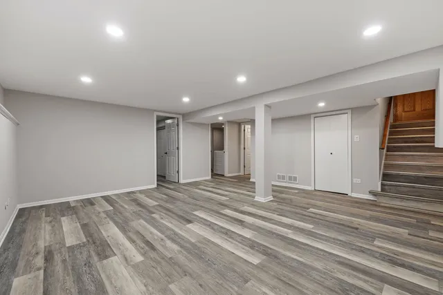 a view of an empty room with wooden floor and entryway