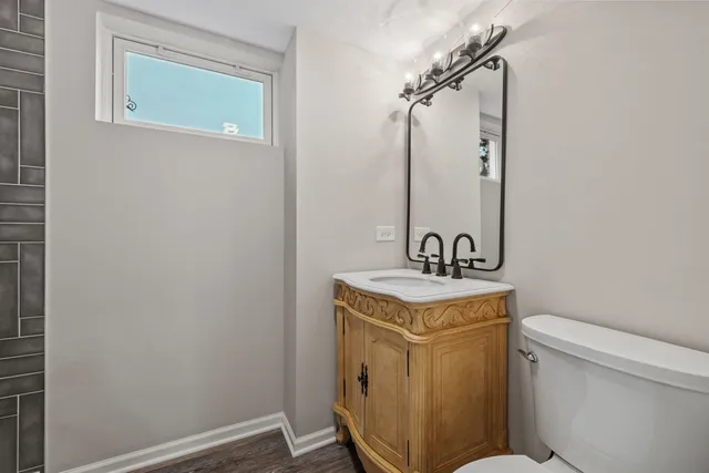 a bathroom with a sink a toilet and a mirror