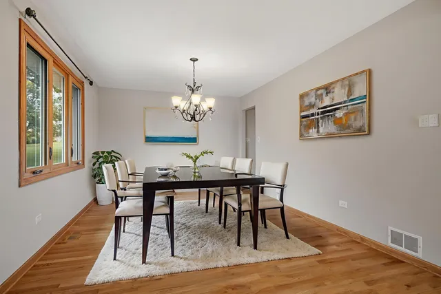a view of a dining room with furniture a chandelier and wooden floor
