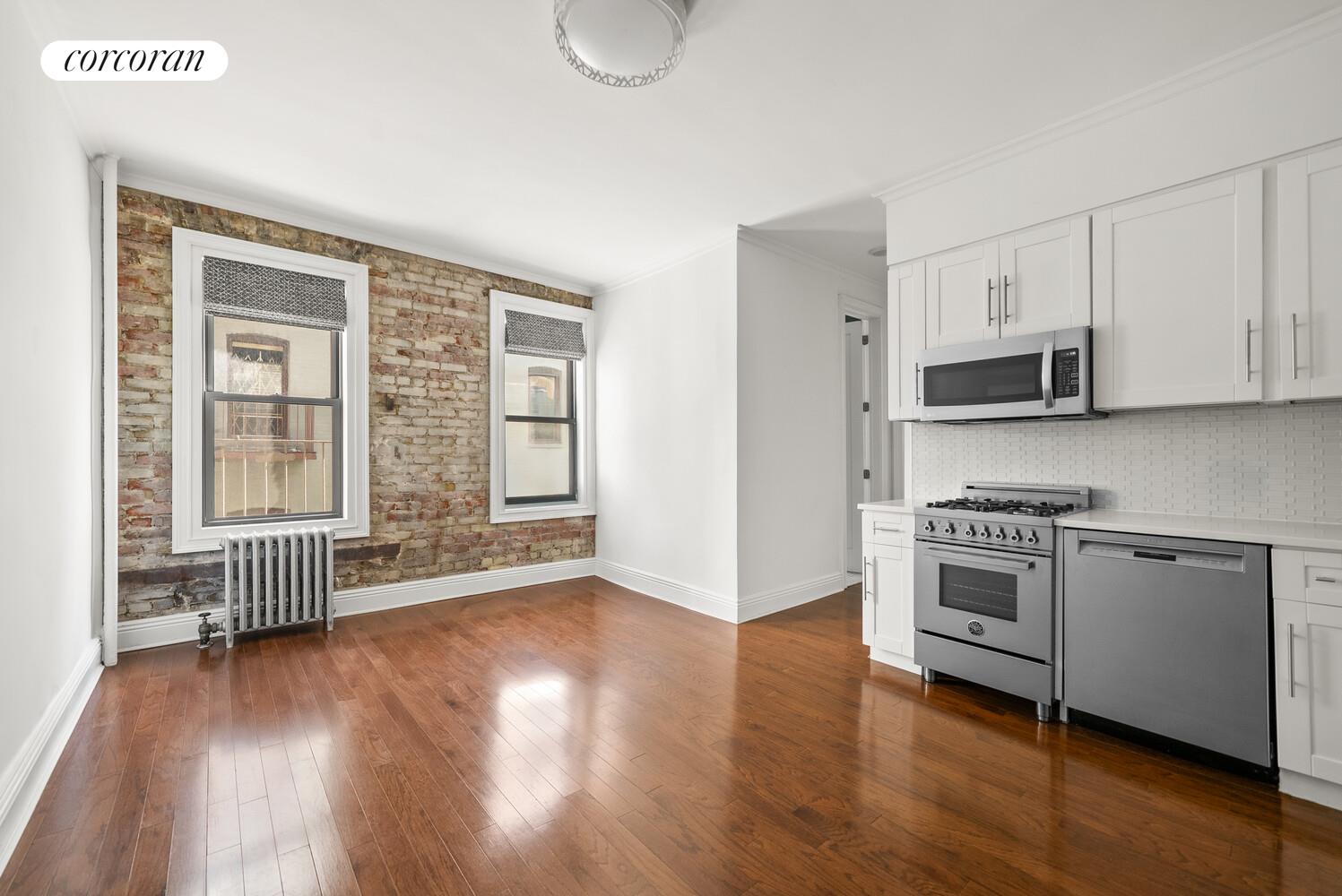 24-51 38th Street, Unit B7 Queens, NY 11103 - Photo 2 of 13 a kitchen with stainless steel appliances granite countertop a stove a sink and white cabinets with wooden floor next to windows