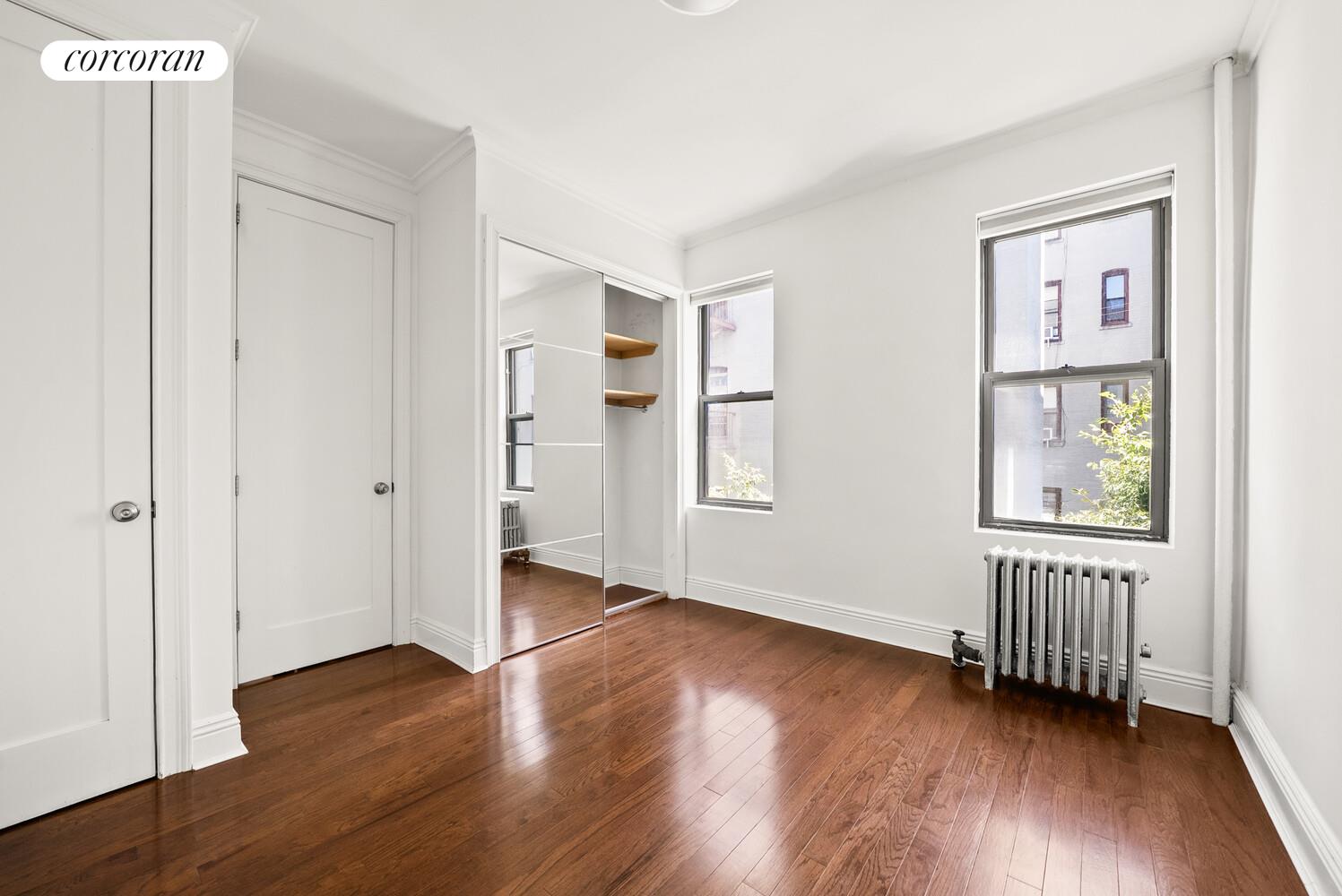 24-51 38th Street, Unit B7 Queens, NY 11103 - Photo 4 of 13 an empty room with wooden floor closet and windows