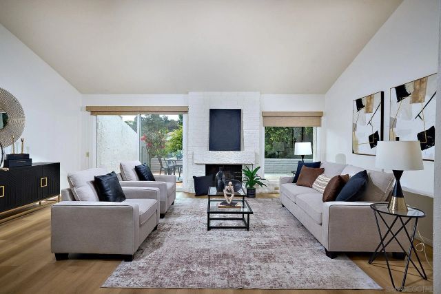 a living room with fireplace furniture and a large window