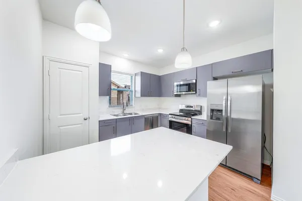 a large kitchen with kitchen island a sink stainless steel appliances and cabinets