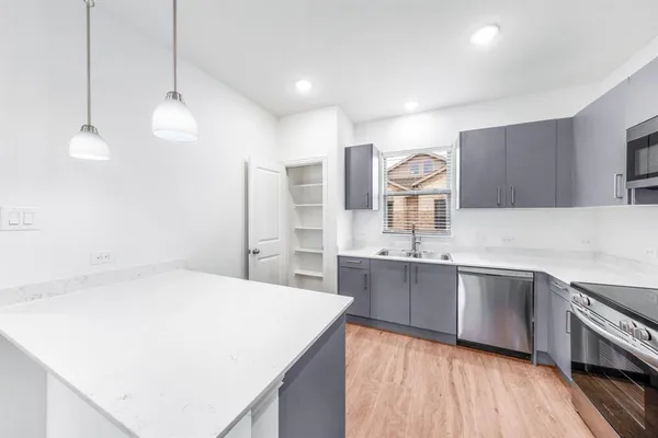 a kitchen with stainless steel appliances granite countertop a sink stove and refrigerator