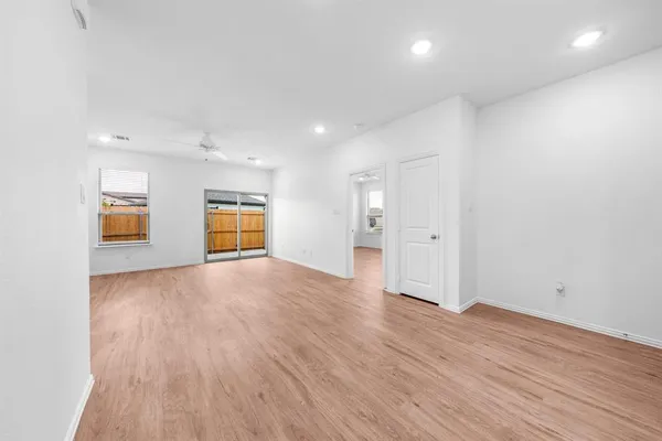 a view of kitchen with kitchen island wooden floors appliances and cabinets