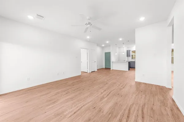 a view of an empty room with window and wooden floor